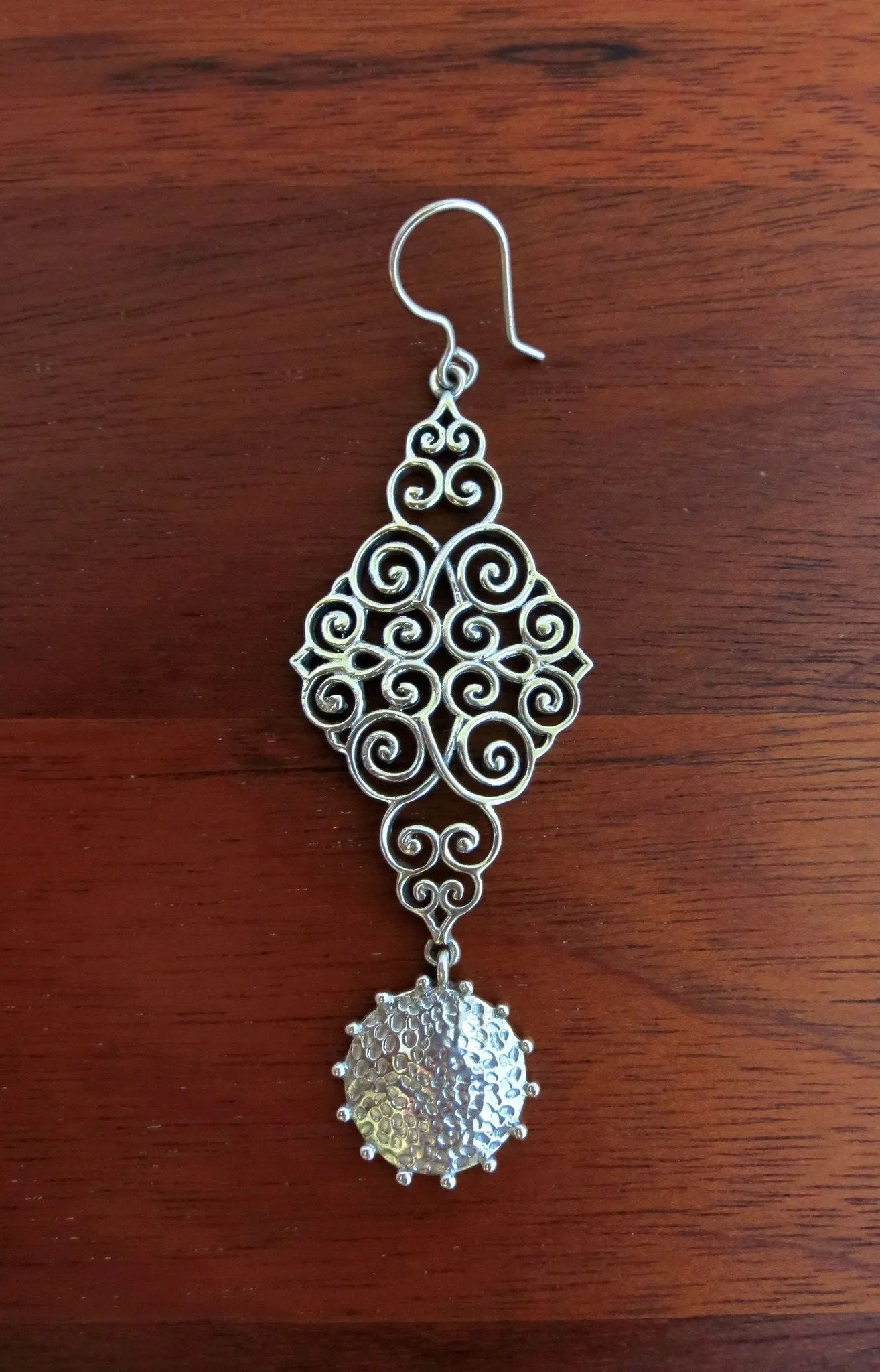 Stunning, wire scroll-pattern earrings with a dangling hammered disc